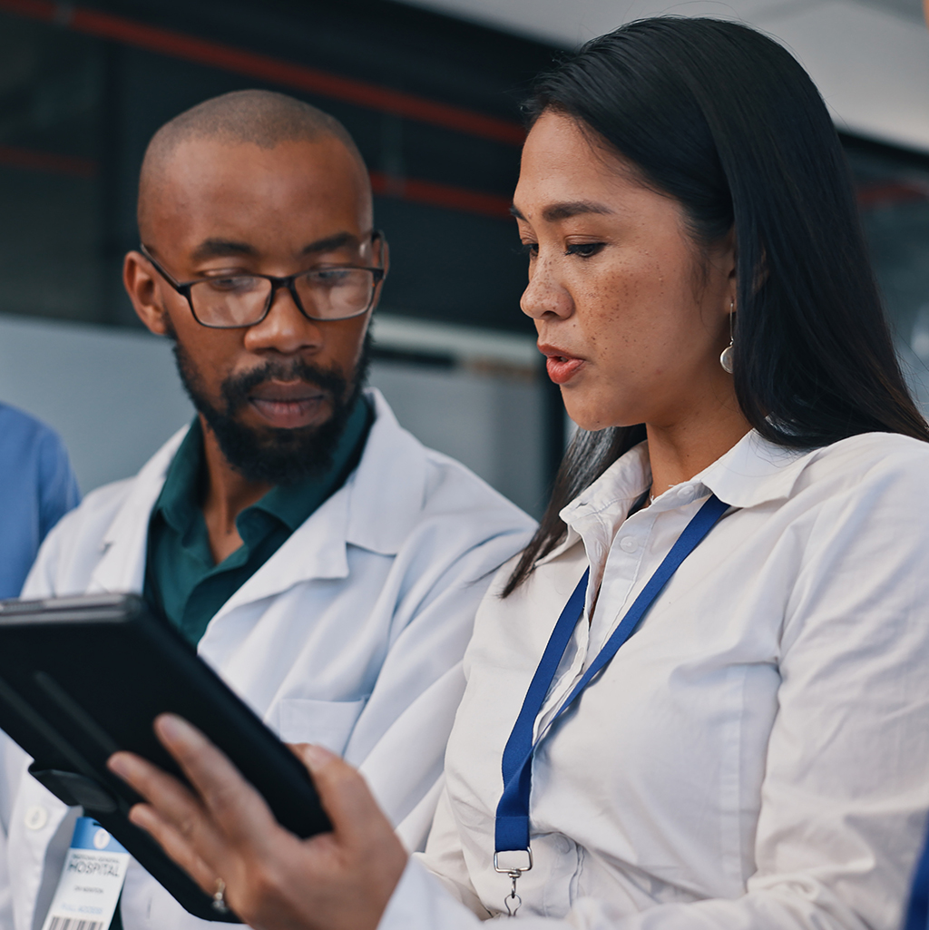 Medical team, tablet and meeting in hospital with doctor, discussion and diversity at work. Healthcare, nursing and health support staff with tech for patient info or test results and communication